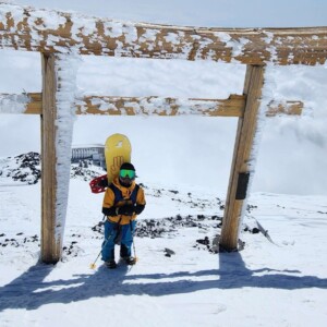 Um guia de montanhismo e snowboarding no Japão. Ele está com seu snowboard amarelo e roupas de inverno. Guia de montanhismo e snowboarding no Japão com snowboard amarelo e roupas de inverno, representando expedições guiadas de montanhismo, esqui e snowboard nas montanhas japonesas.