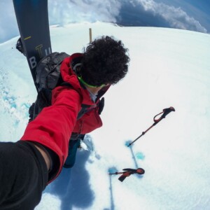Um guia de montanhismo e snowboarding no Japão. Ele está usando roupas vermelhas de inverno. Guia de montanhismo, snowboarding e esqui Daniel Tamaki no Japão usando roupas vermelhas de inverno, representando expedições guiadas de montanhismo, esqui e snowboard nas montanhas japonesas.